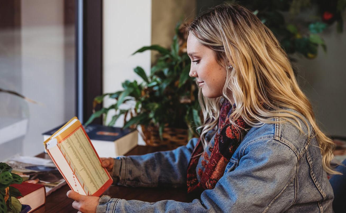 Female student smiling and reading book